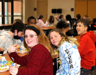  Three middle school students eating lunch in the school cafeteria